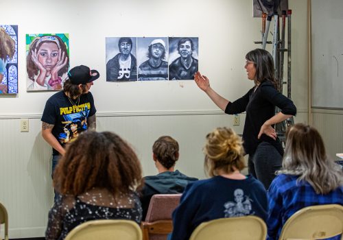 Art faculty and students looking at work during a critique